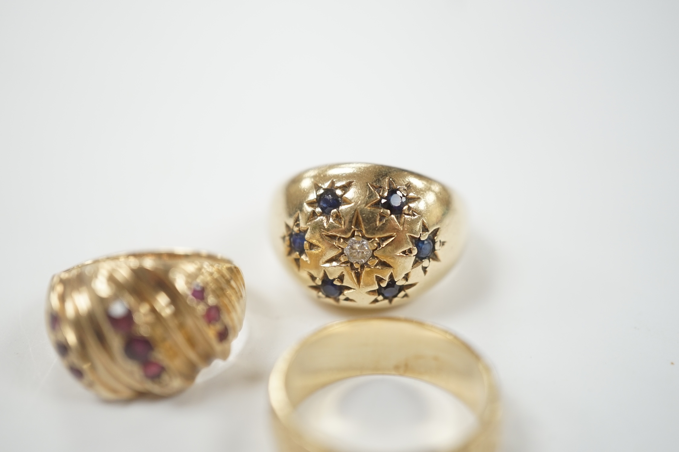 Two modern 9ct gold and gem set dress rings and a similar engraved 9ct gold band